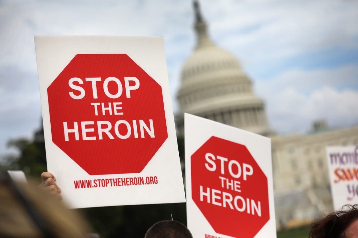 Photo showing protest signs saying, "STOP THE HEROIN," with the Capitol building in the background