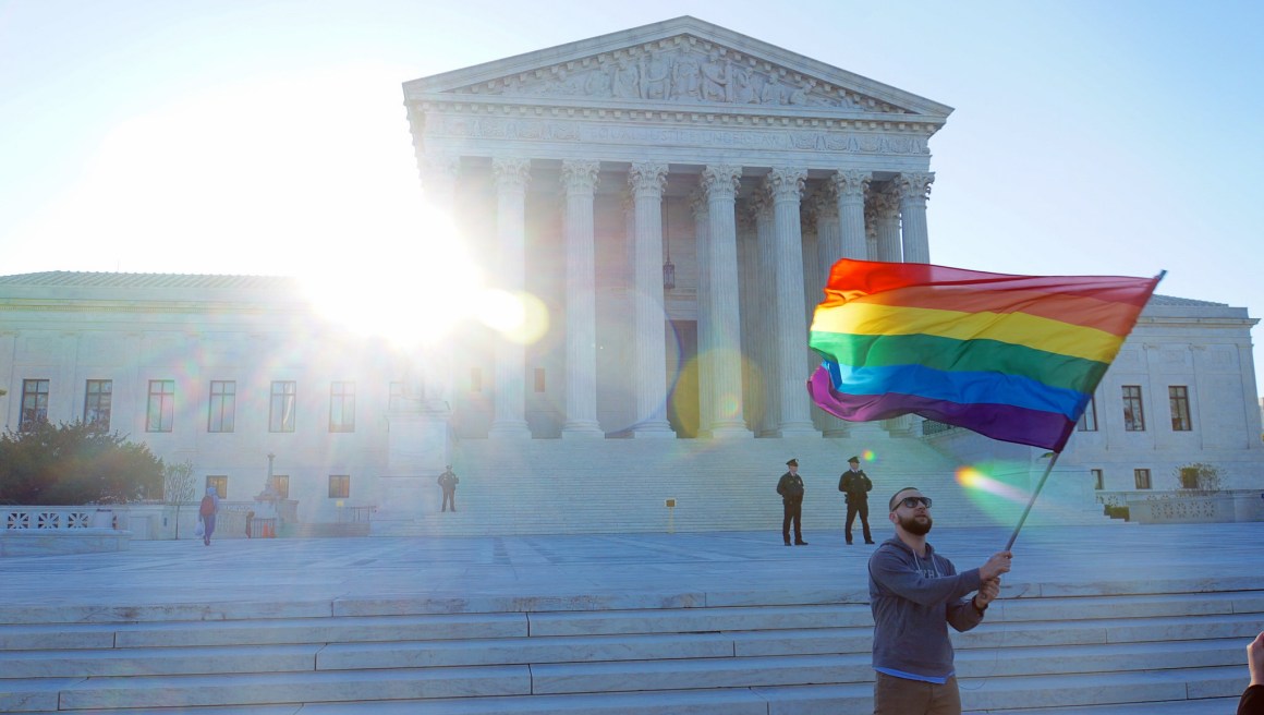 A student waves a Pride flag,