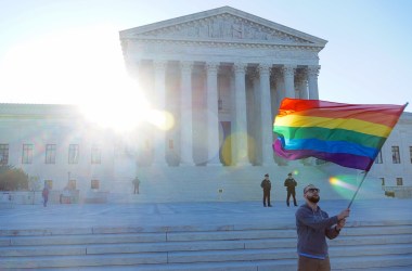 A student waves a Pride flag,