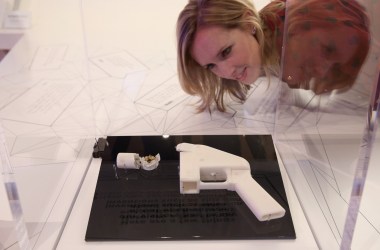 A woman admires a 3-D printed handgun on display in a museum.