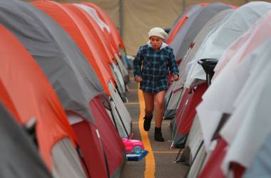 A resident of the Alpha Project campsite walks between tents.