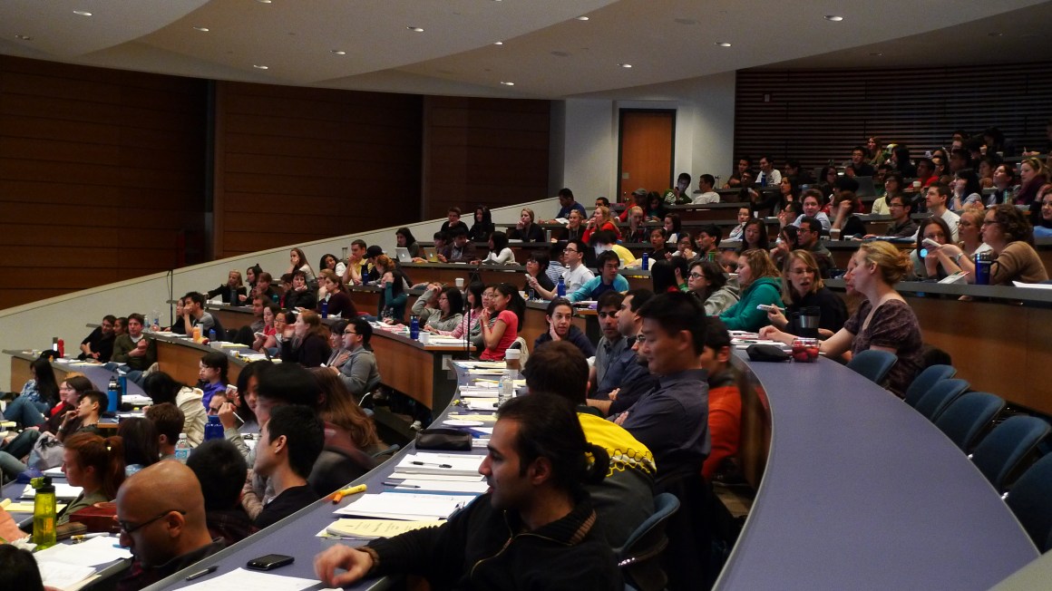 Students sit in a college lecture hall.