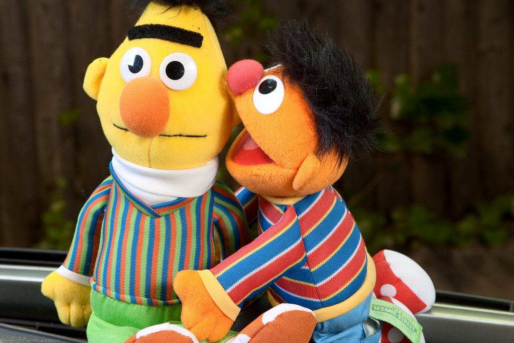 Bert whispers in Ernie's ear on Sesame Street.