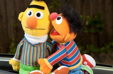 Bert whispers in Ernie's ear on Sesame Street.