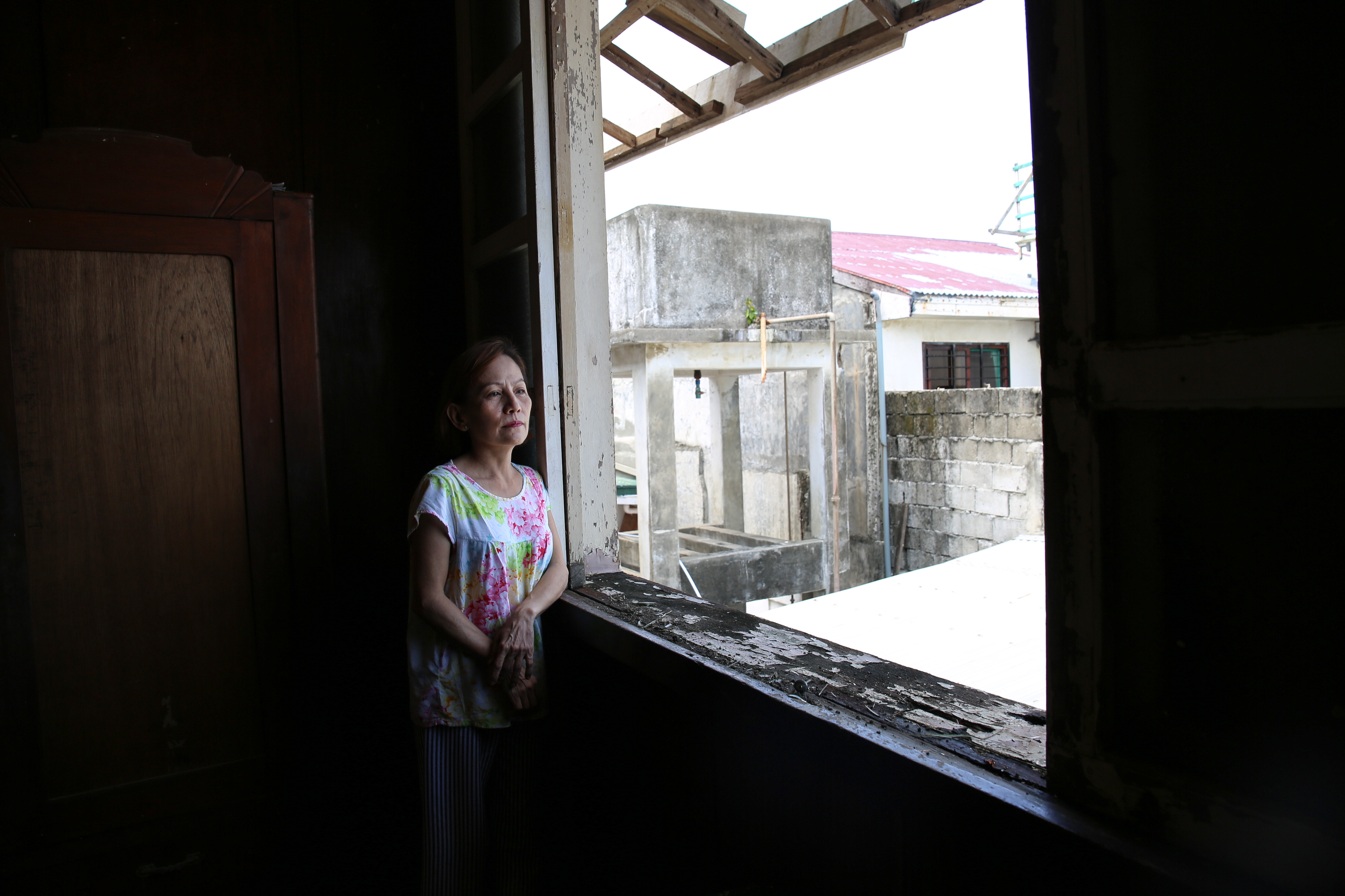 Vicky Romillio Verzoso, 58, stands in her bedroom. 