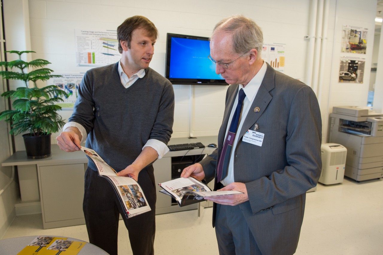 Photo showing Representative Bill Foster and another man looking at booklets in an office