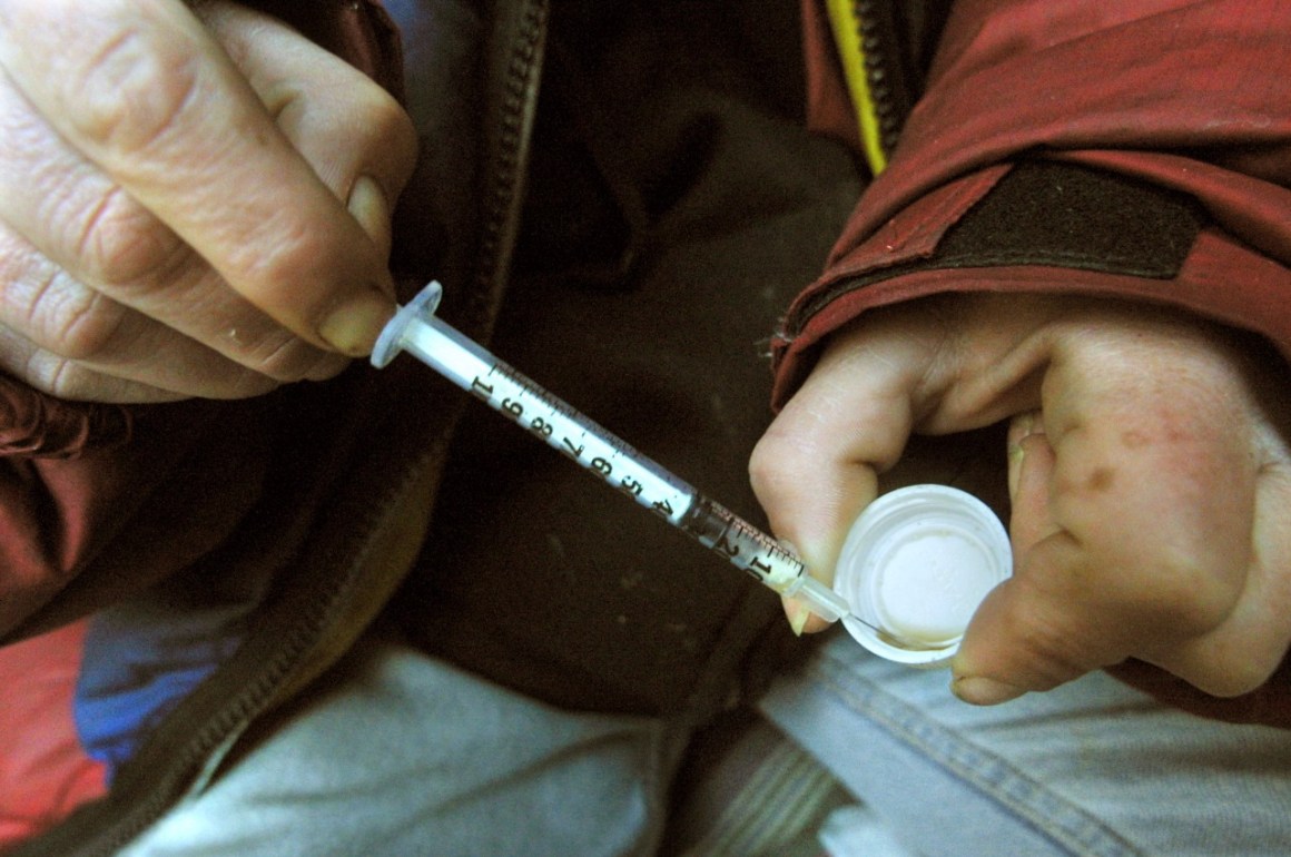 Photo showing someone drawing fluid into a needle