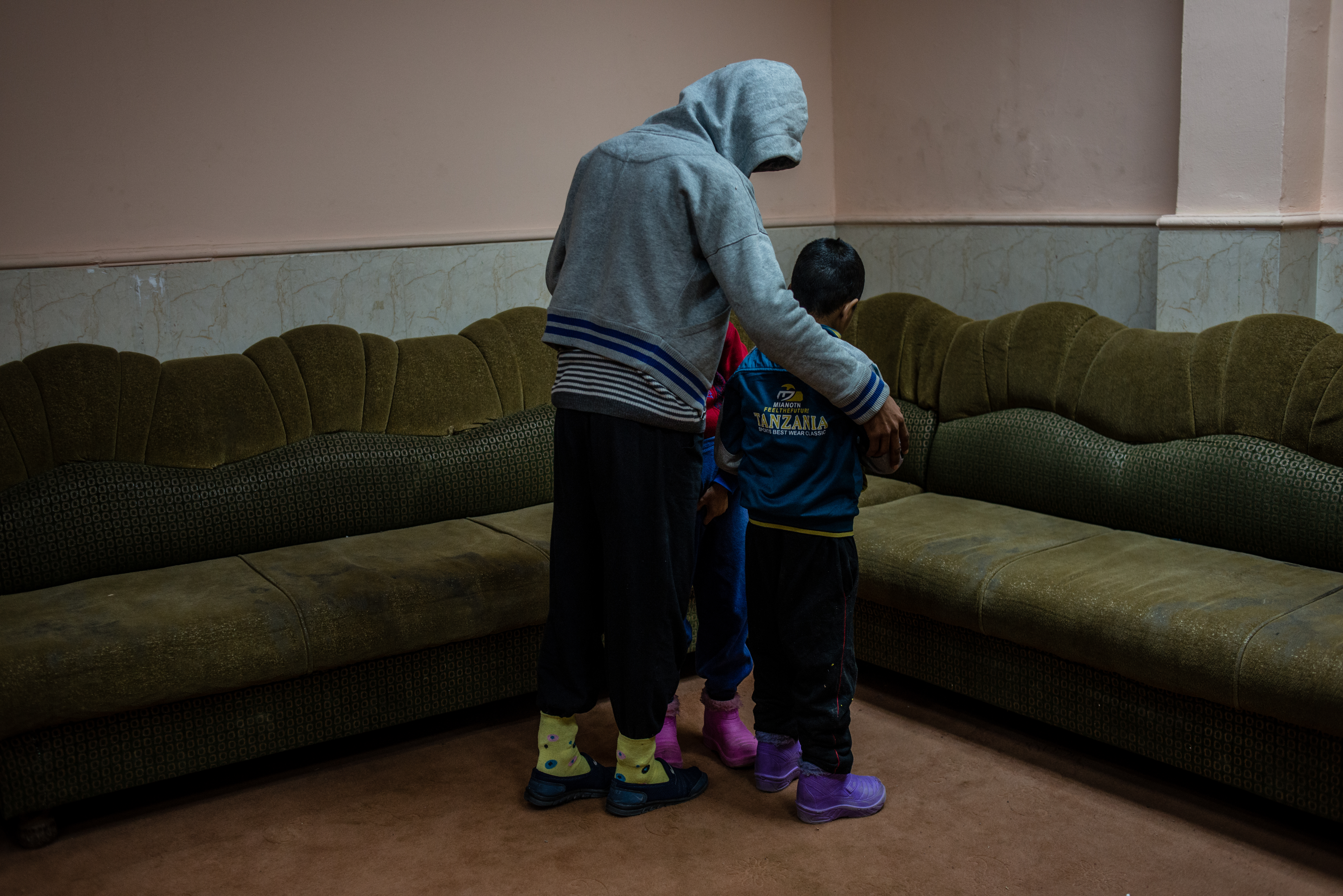 Two disabled boys, found wandering around playground city alone, are shielded by an older resident at the Mosul orphanage.