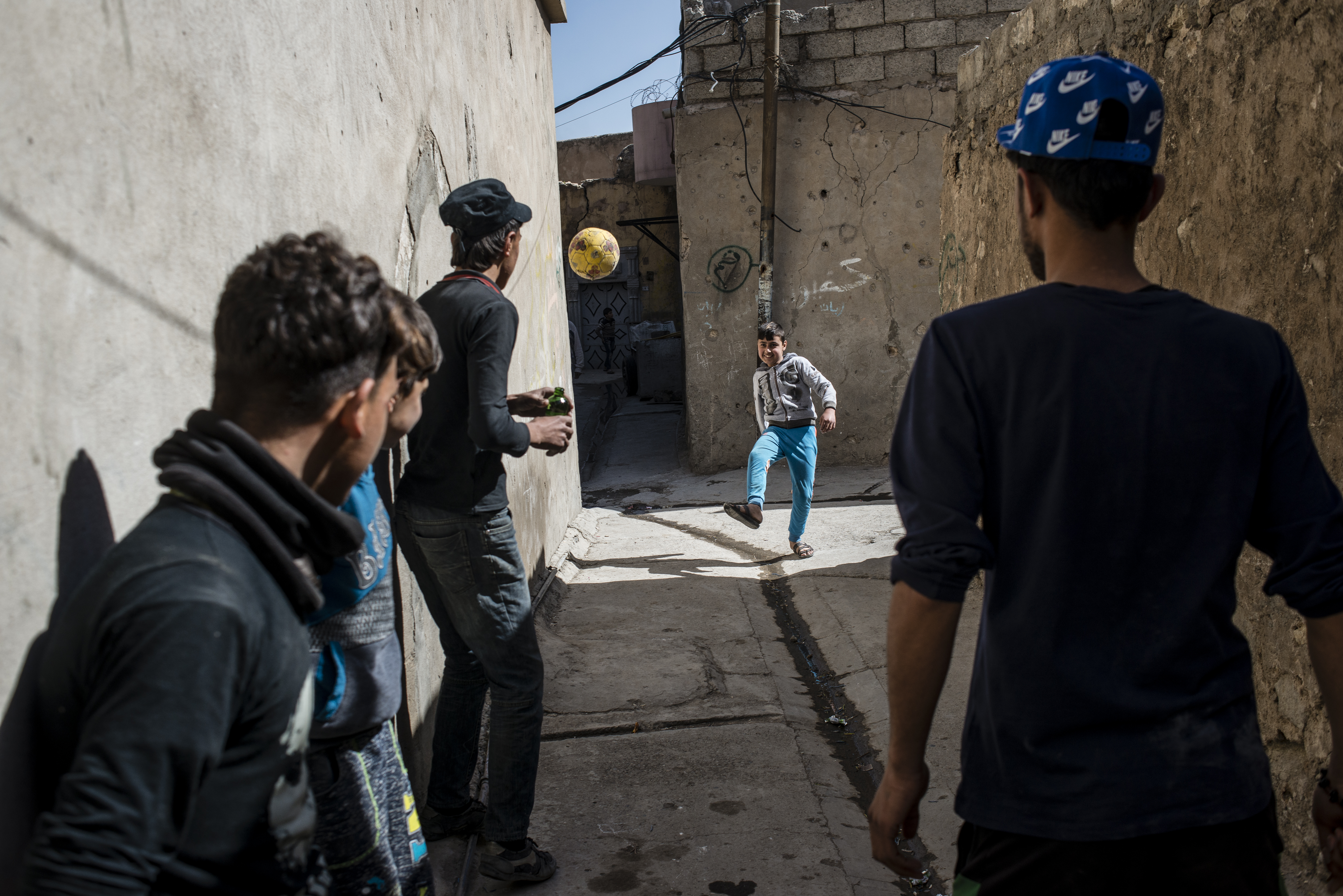 Ali, a boy who lost his arm in a mortar strike while his family was displaced, plays with his friends in the Old City once again.