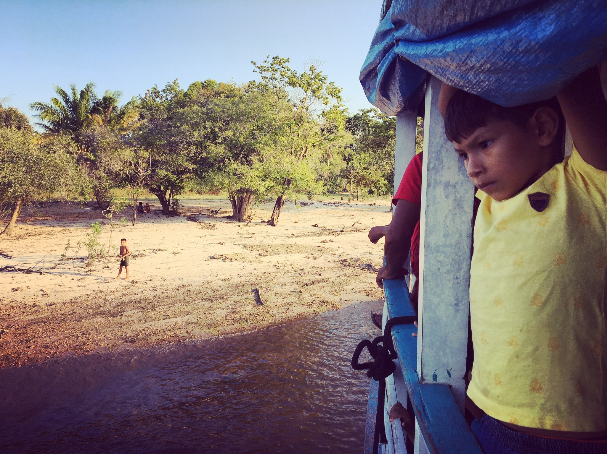 A little boy looks out during one of the stops the Michael made along our route between Santarem and São Pedro.