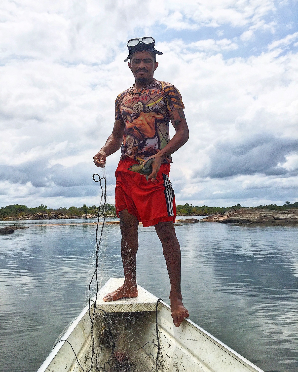 Caboco holds an Acari fish on a Sunday fishing trip.