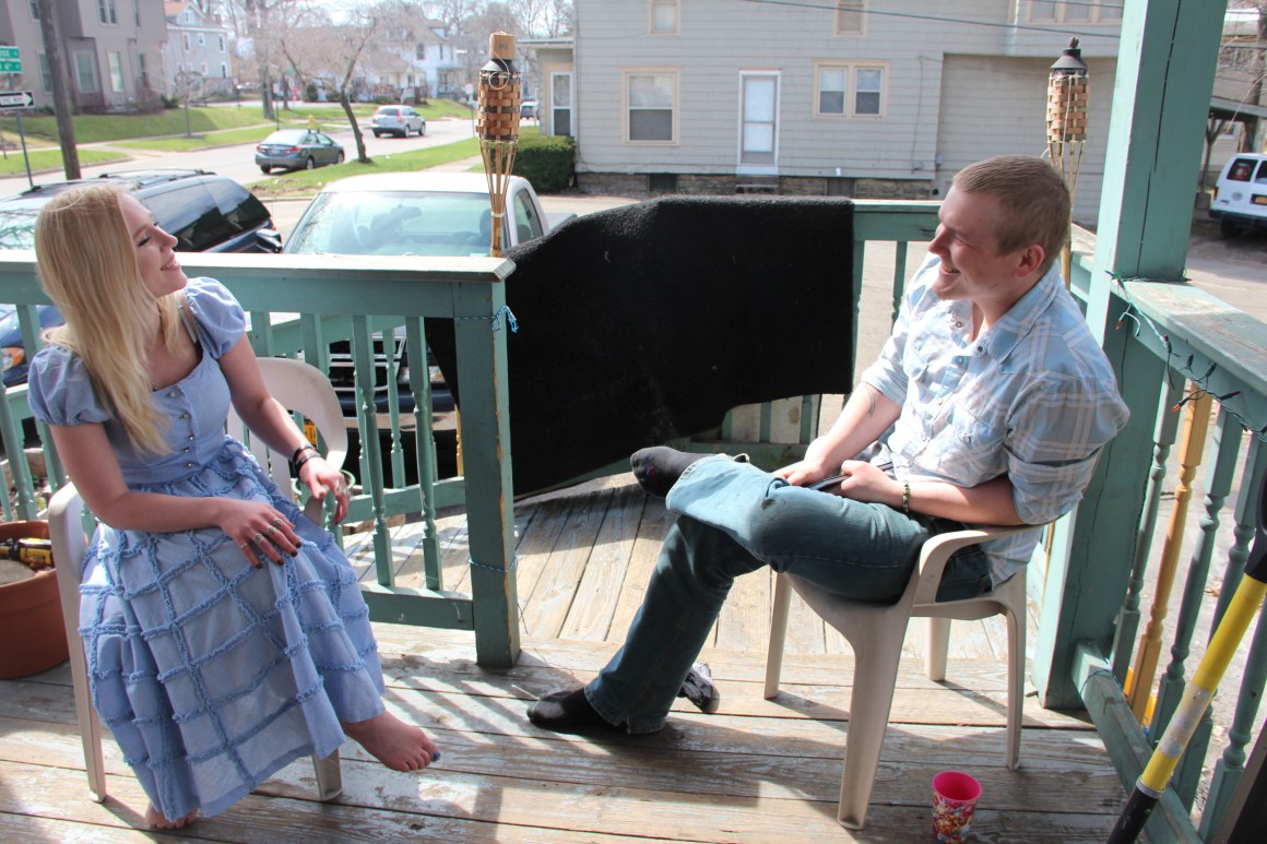 Chanda Lynn Germain and Zack Dahlbeck sit talking on their porch at home in Jamestown, New York.