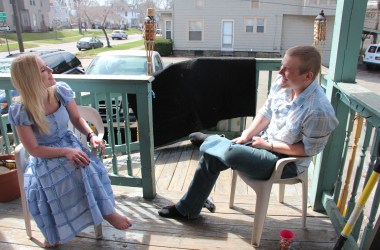 Chanda Lynn Germain and Zack Dahlbeck sit talking on their porch at home in Jamestown, New York.