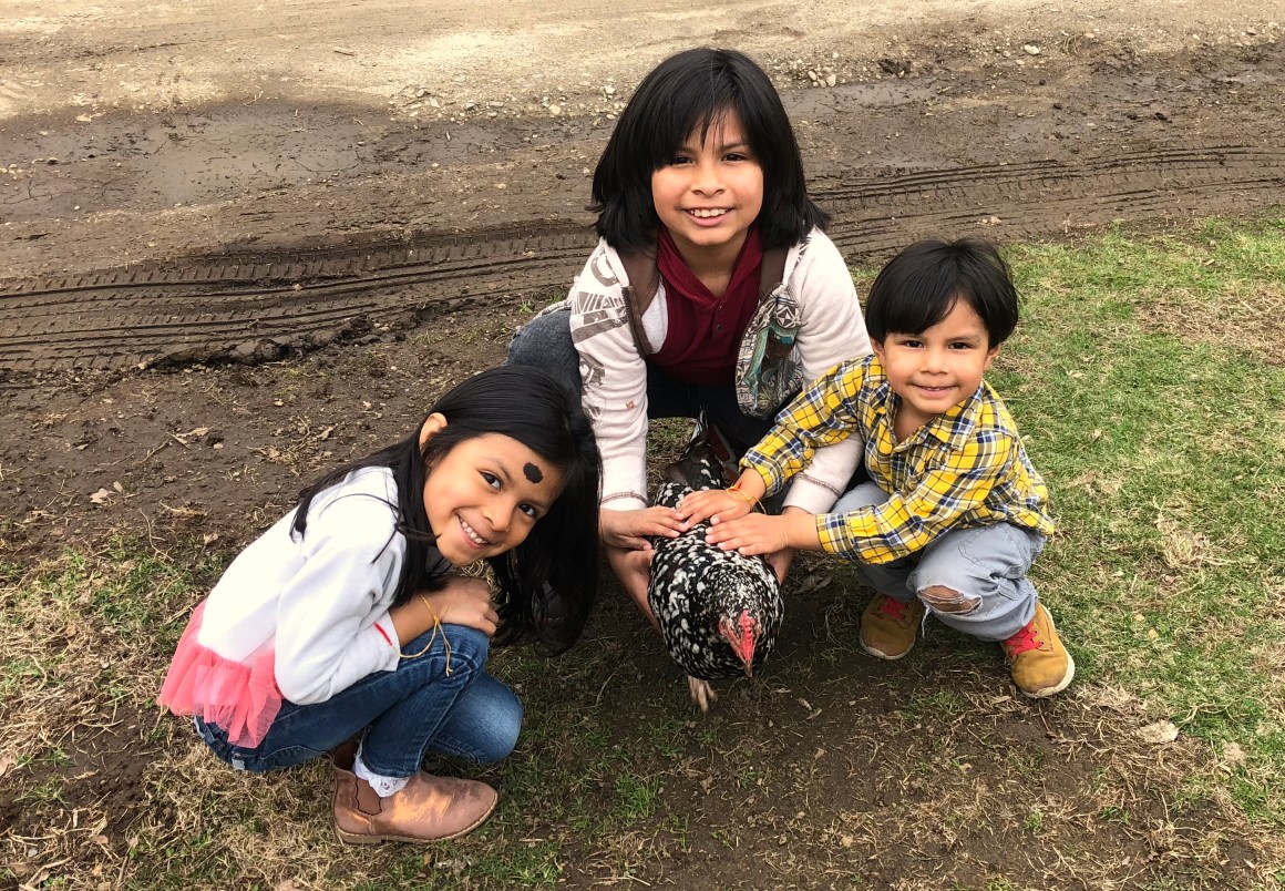 The Ramirez family with a Speckled Sussex Chicken named Nora the Explora.