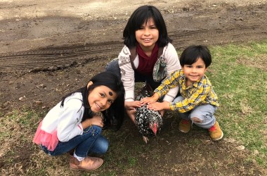 The Ramirez family with a Speckled Sussex Chicken named Nora the Explora.