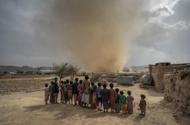 In April, children watch a dust devil whip up sand as it travels across the desert landscape near the town of Huth, about 50 miles north of Yemen's capital.