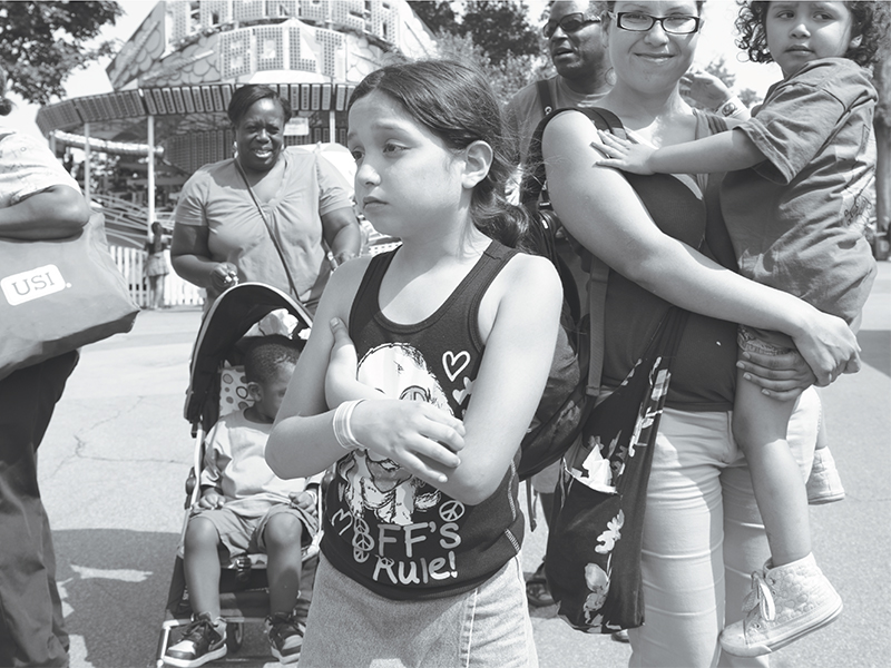 Dee's Tots organizes field trips, such as this one to a nearby amusement park. Eight-year-old Diana was unhappy because her mother (holding her four-year-old daughter, Ivette) had to end the outing and leave for work.