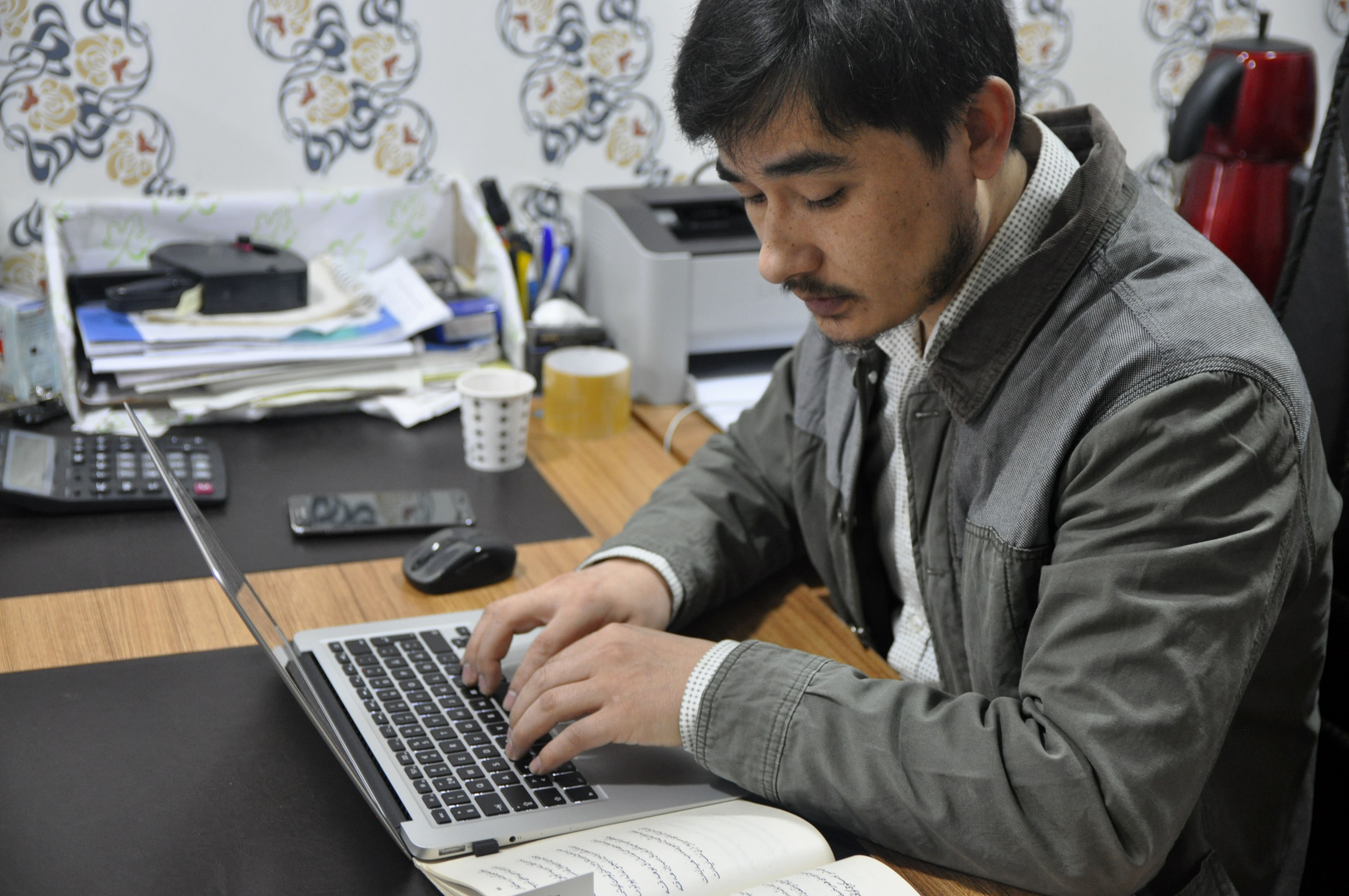 Ershat Bahtiyar, 27, digitizes an older volume by typing it directly into a word document. This one, he says, will take two days to complete.