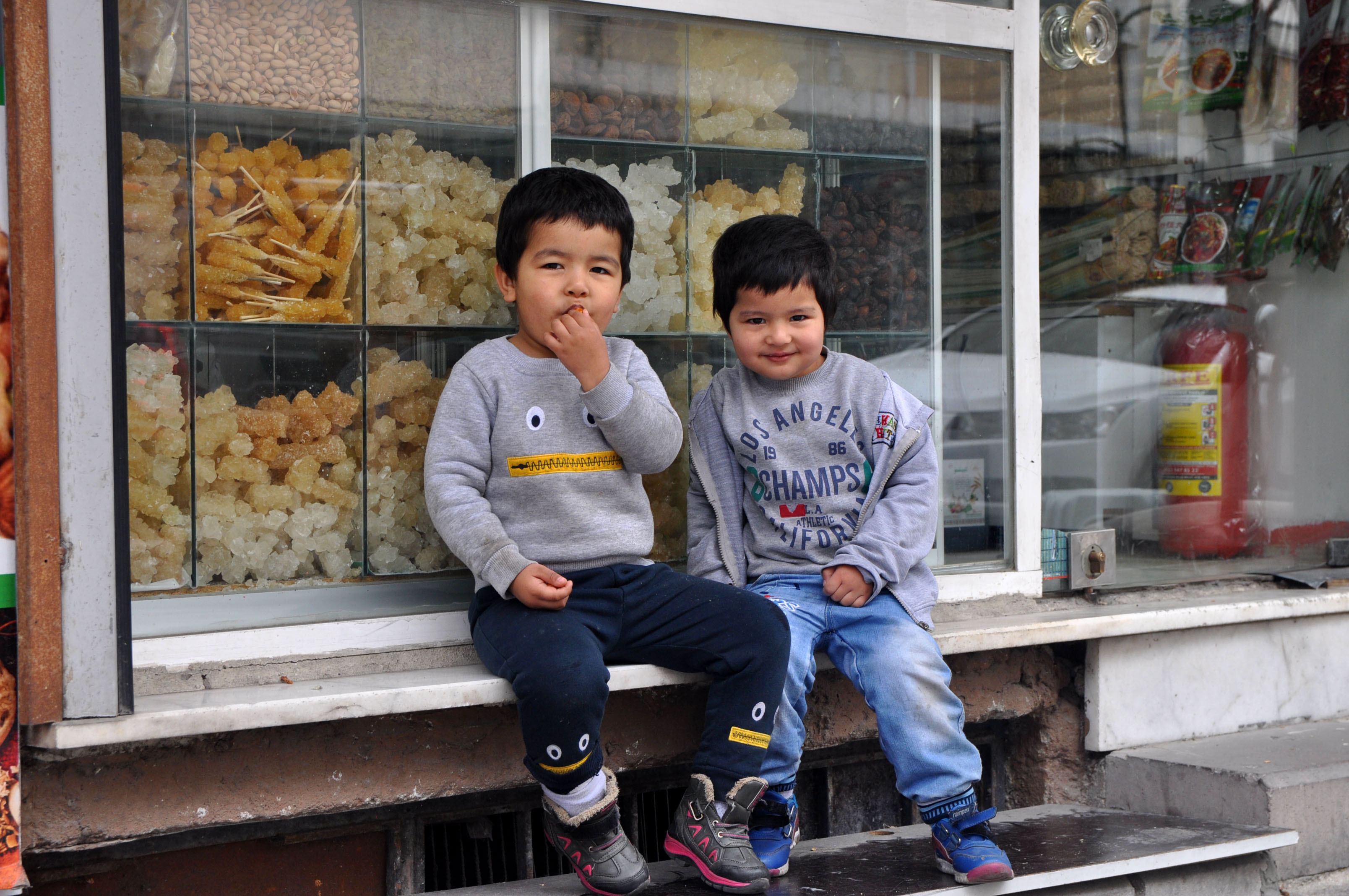 Emmar, 4, and Muhammed, 3, sit outside a candy shop near their father's cell phone store. The neighborhood of Zeytinburnu boasts one of Istanbul's largest collections of Uyghur-owned shops, businesses, and restaurants.