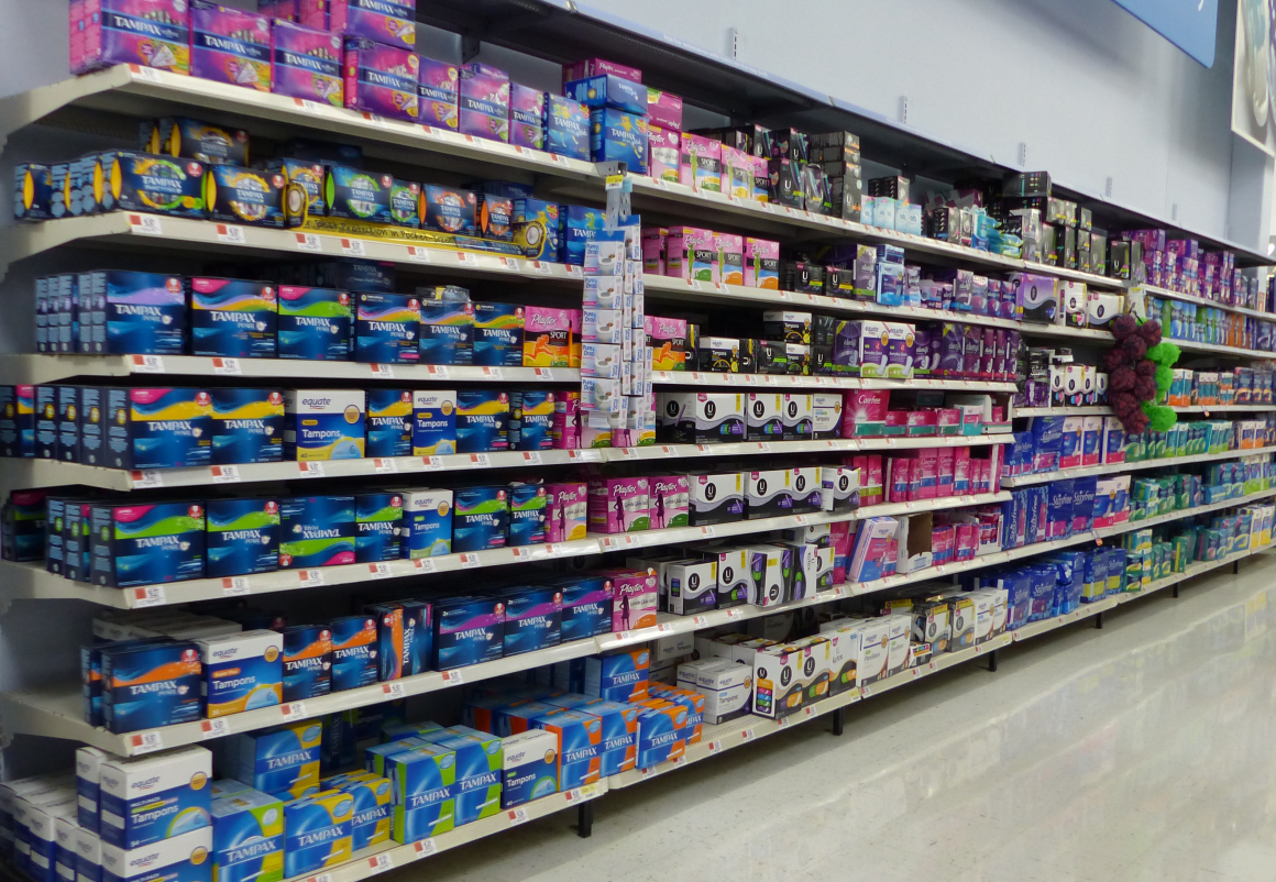 Feminine hygiene products such as tampons and pads in a Walmart aisle