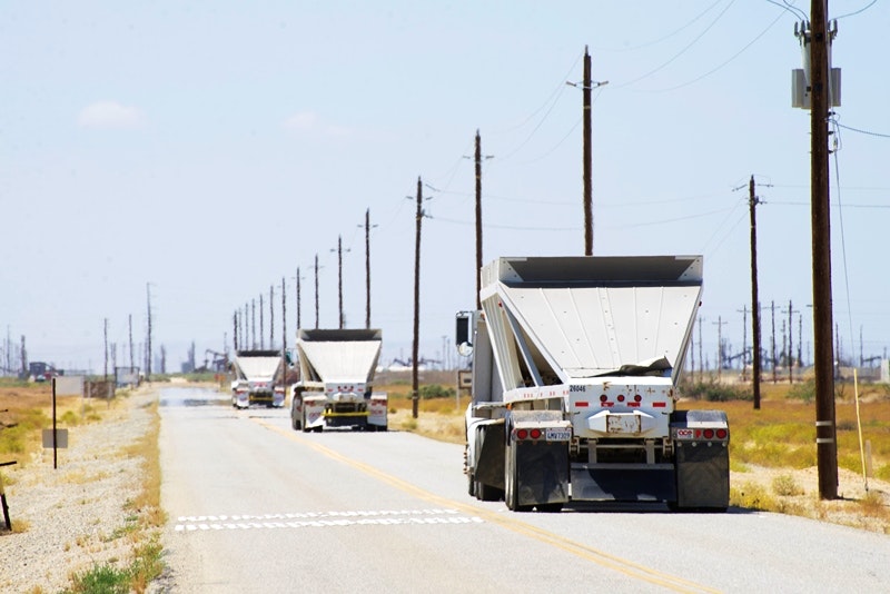 Trucks enter an oilfield in Kern County. San Joaquin Valley residents face a range of health issues, including air pollution from vehicles and industry in the region.