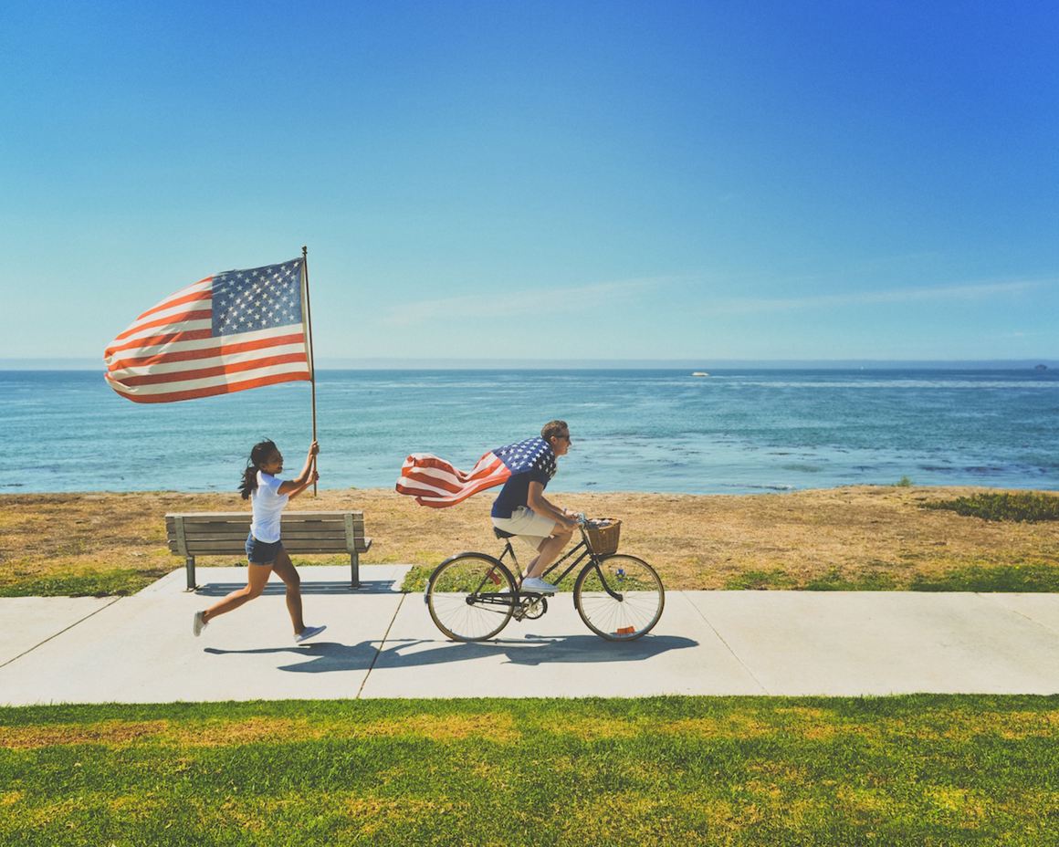 man woman american flag beach  water ocean