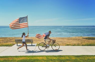 man woman american flag beach  water ocean