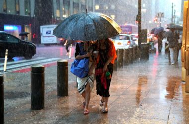 People take cover from the rain in Midtown New York on July 17th, 2018, as a sudden storm hit the area with flash food warning in the Tri-State area.