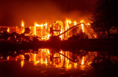 A burning home is reflected in a pool during the Carr fire in Redding, California, on July 27th, 2018.