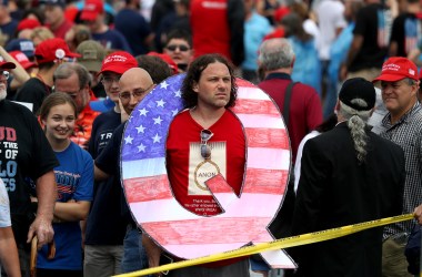 A man holds a large Q sign, referencing the Qanon conspiracy theory, at a rally for President Donald Trump on August 2nd, 2018, in Wilkes Barre, Pennsylvania.