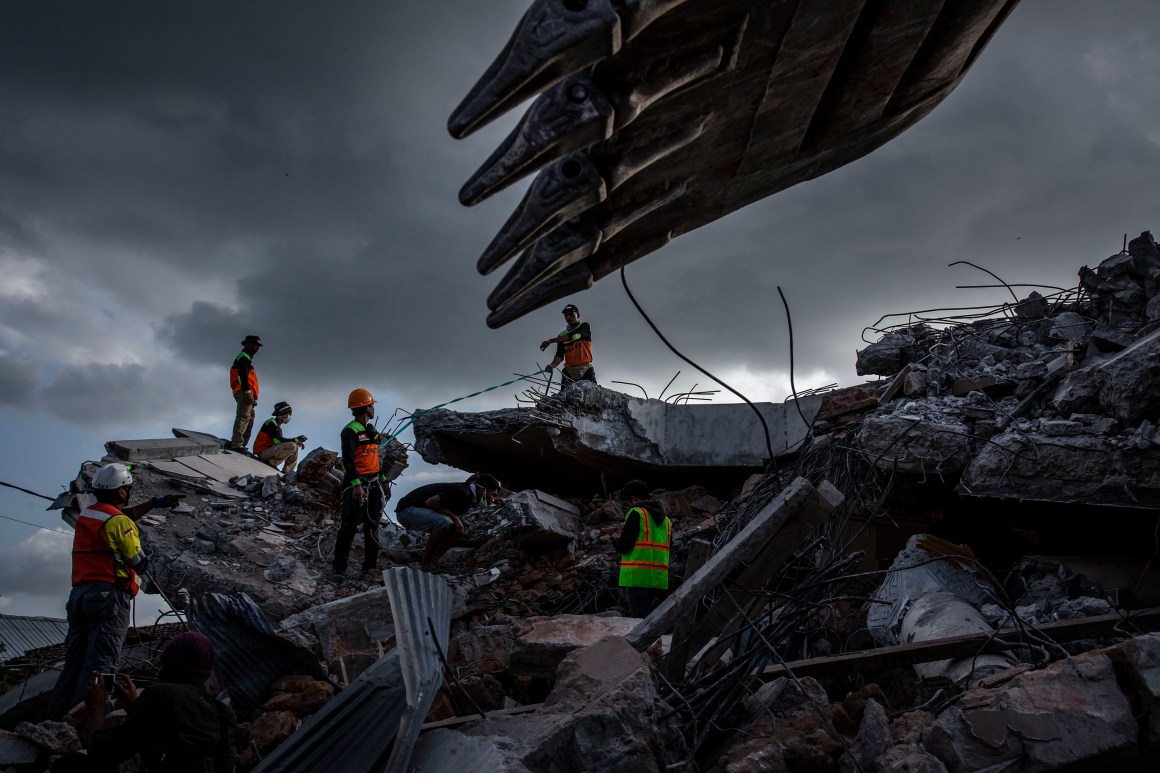 An Indonesian search-and-rescue team looks for victims under a collapsed mosque following an earthquake on August 7th, 2018, in Lombok Island, Indonesia. Nearly 100 people have been confirmed dead and at least 20,000 people have been left homeless after the 6.9 magnitude earthquake hit Lombok and neighboring Bali.