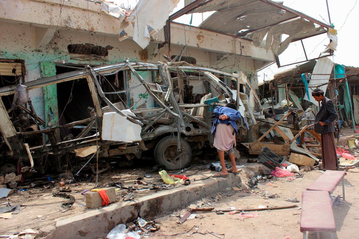 Yemenis gather next to the destroyed bus at the site of a Saudi-led coalition airstrike, on August 10th, 2018.