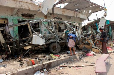 Yemenis gather next to the destroyed bus at the site of a Saudi-led coalition airstrike, on August 10th, 2018.