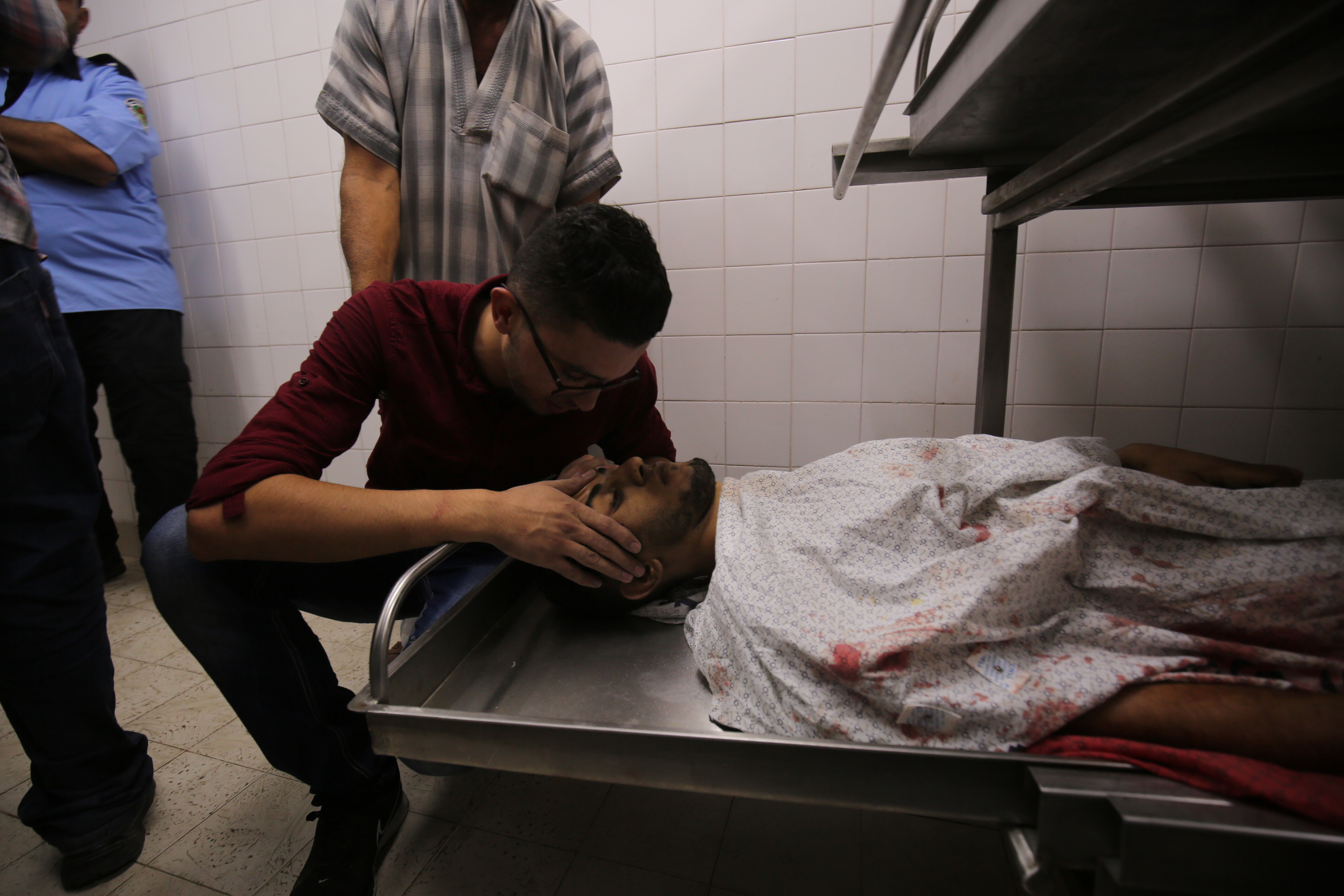 A relative of Palestinian paramedic Abdullah al-Qotati, who was killed while trying to help wounded protesters at the Israel-Gaza border, reacts over his body at a hospital in Khan Yunis in the southern Gaza Strip on August 10th, 2018.