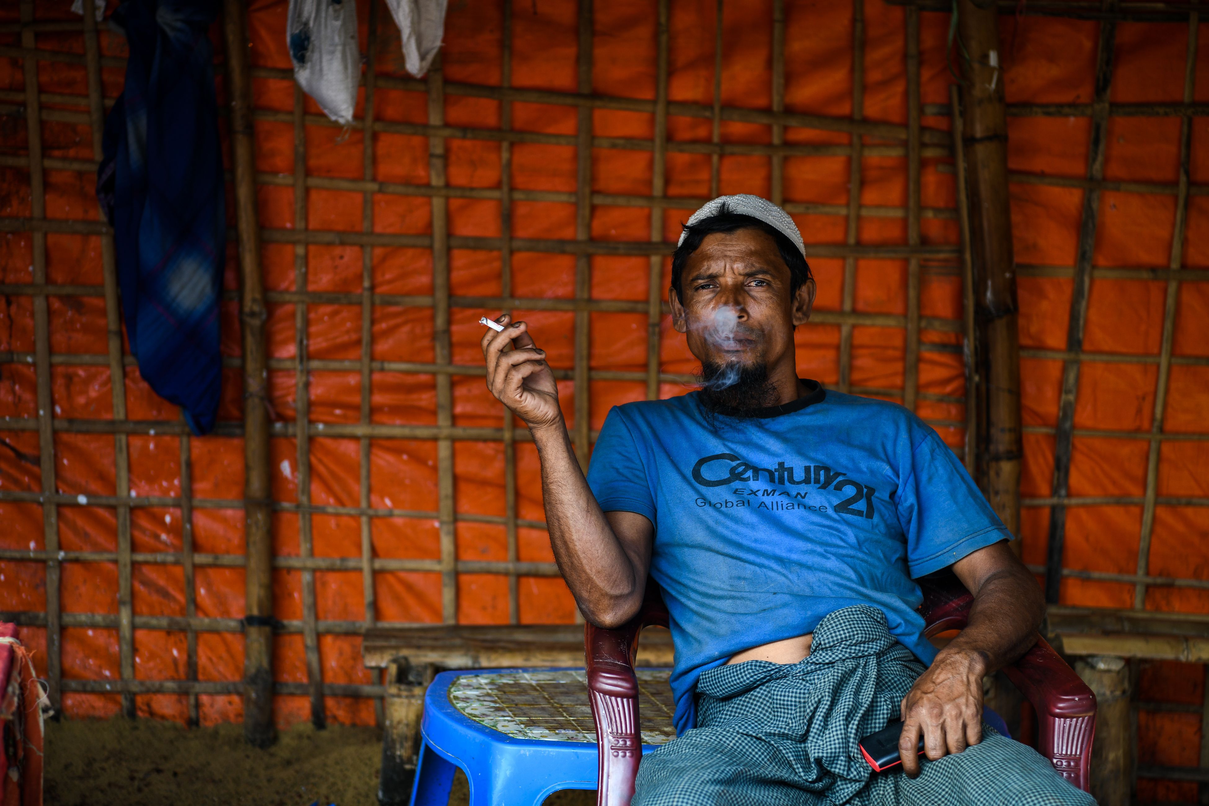 A Rohingya refugee man smokes inside a local food joint in the Kutupalong refugee camp in Ukhia on August 14th, 2018.