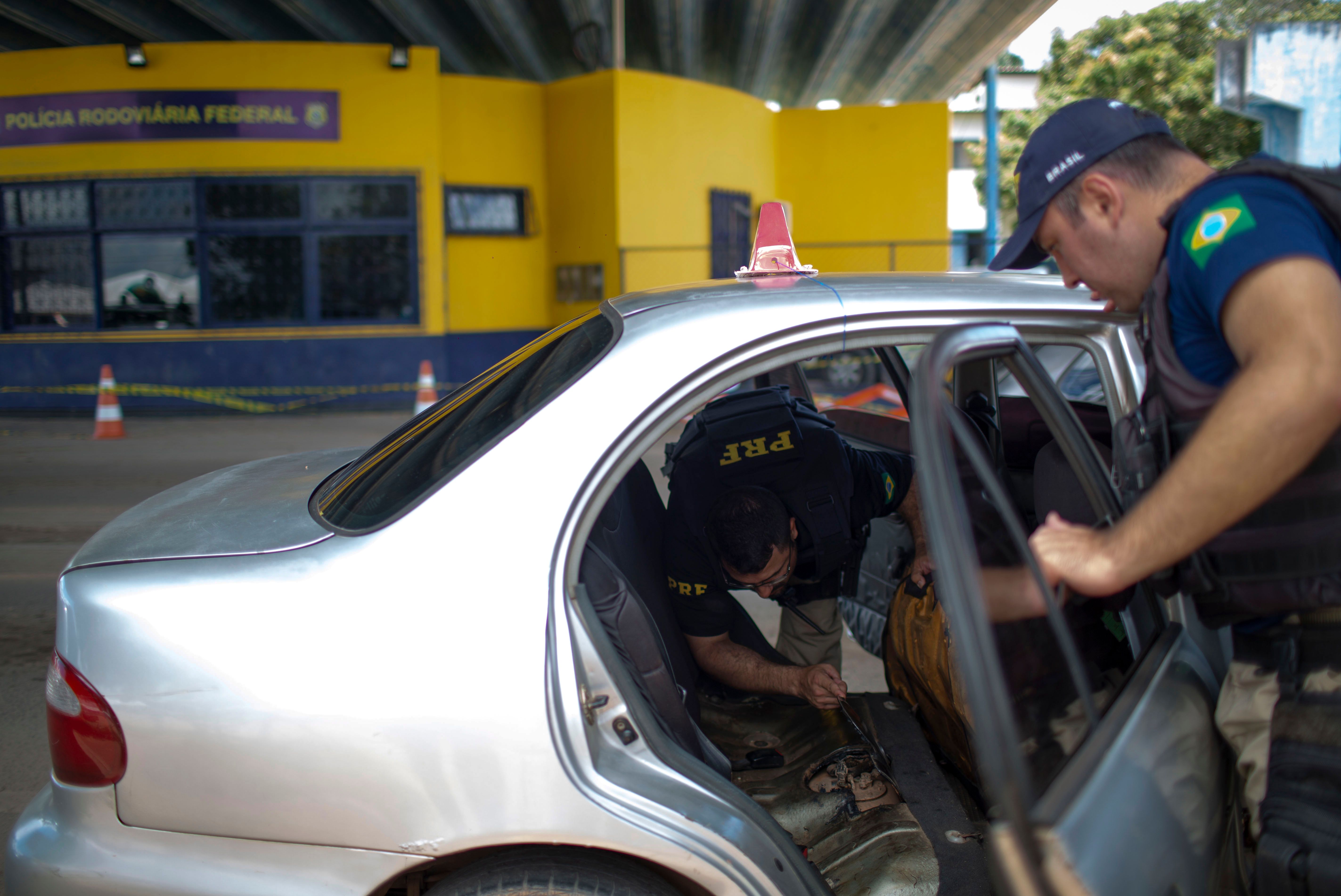 Brazilian Federal Road Police officers check a Venezuelan taxi on its way to Brazil at the Brazilian Migration Office in the border city of Pacaraima, Roraima State, Brazil, on August 20th, 2018.