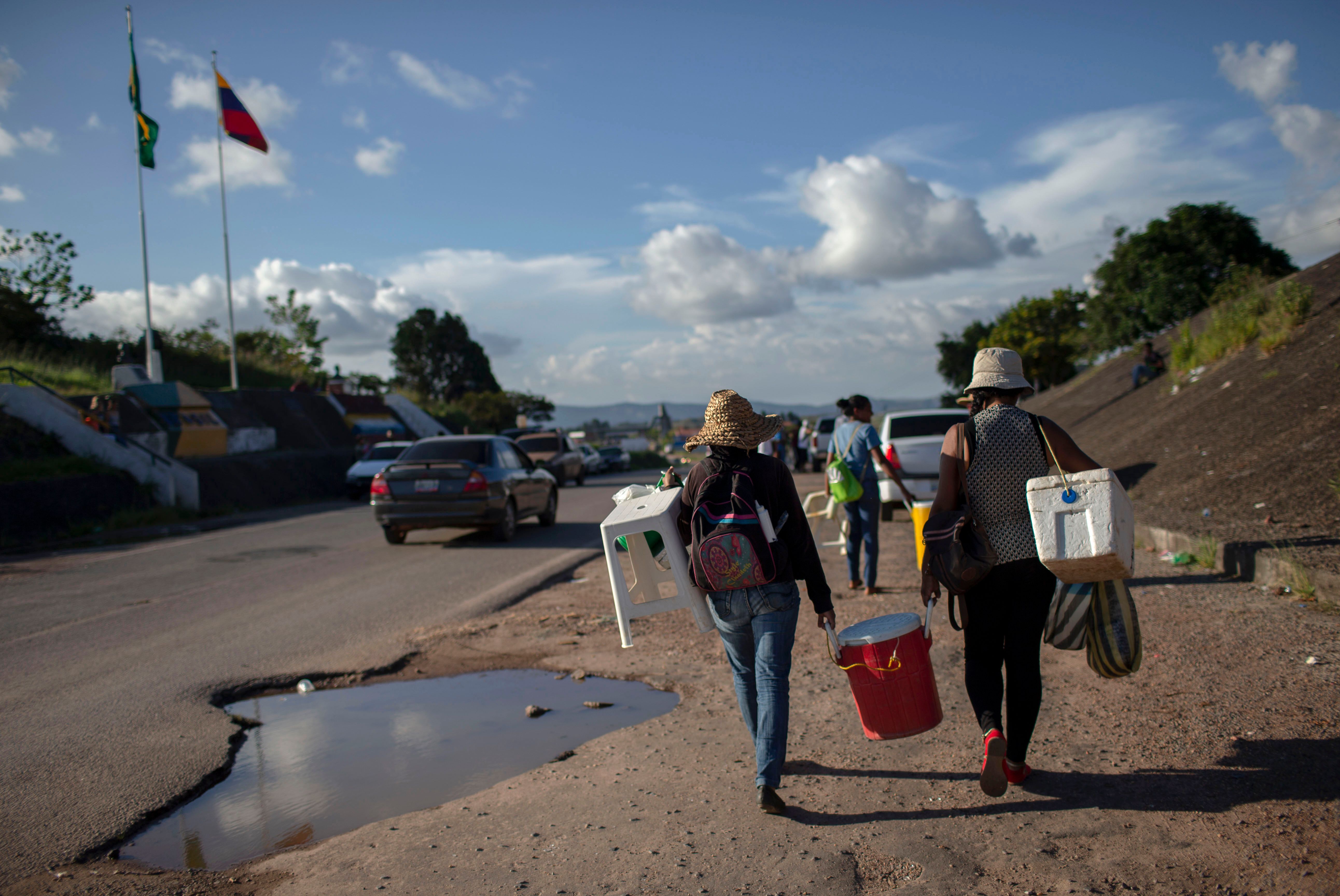 Venezuelan women walk back to their country after a day selling soft drinks and snacks in the Brazilian border in the city of Pacaraima, in Roraima State, on August 21st, 2018.