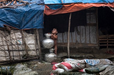 A young child stands under a shelter as monsoon rains hit on August 28th, 2018, in Unchiprang refugee camp, Cox's Bazar, Bangladesh. Tuesday marked the one-year anniversary since a wave of violence forced more than 720,000 Rohingya to flee into the Cox's Bazar district. United Nations investigators said on Monday that Myanmar's army had carried out genocide against the Rohingya in Rakhine state, and that its top military figures must be investigated for crimes against minorities across the country. The U.N. report accused Myanmar's military of murders, imprisonments, enforced disappearances, torture, rape, and other forms of sexual violence in Rakhine state, all of which constitute crimes against humanity.