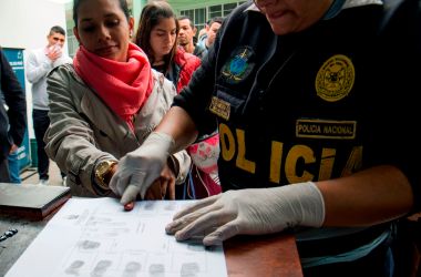 A policeman takes fingerprints of a Venezuelan migrant as a group of migrants wait to apply for resident visas or temporary stay permits at an Interpol facility in Lima, Peru, on August 29th, 2018. Last Friday, Peru enacted rules that mandated that Venezuelans coming into the country show a passport (previously, the law only required an identification card). Since then, hundreds of Venezuelans have applied for asylum in Peru. As Venezuela suffers an unprecedented economic and humanitarian crisis, hundreds of thousands of Venezuelans have fled into other South American countries, escaping intolerable food and medicine shortages in their home country.