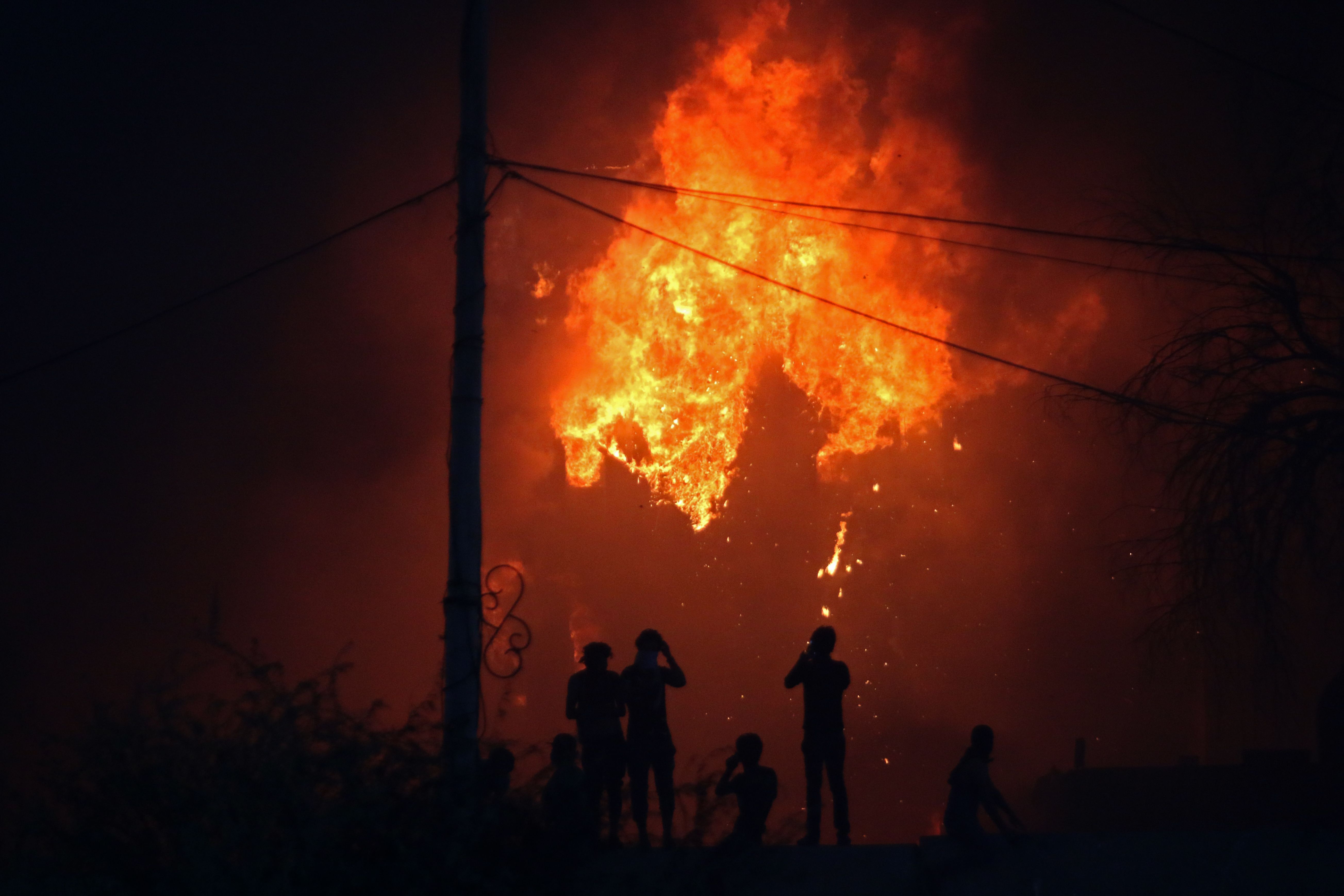 Iraqi protesters watch an official building go up in flames as they demonstrate against the government in Basra on September 6th, 2018. A curfew was imposed in the city that same day.