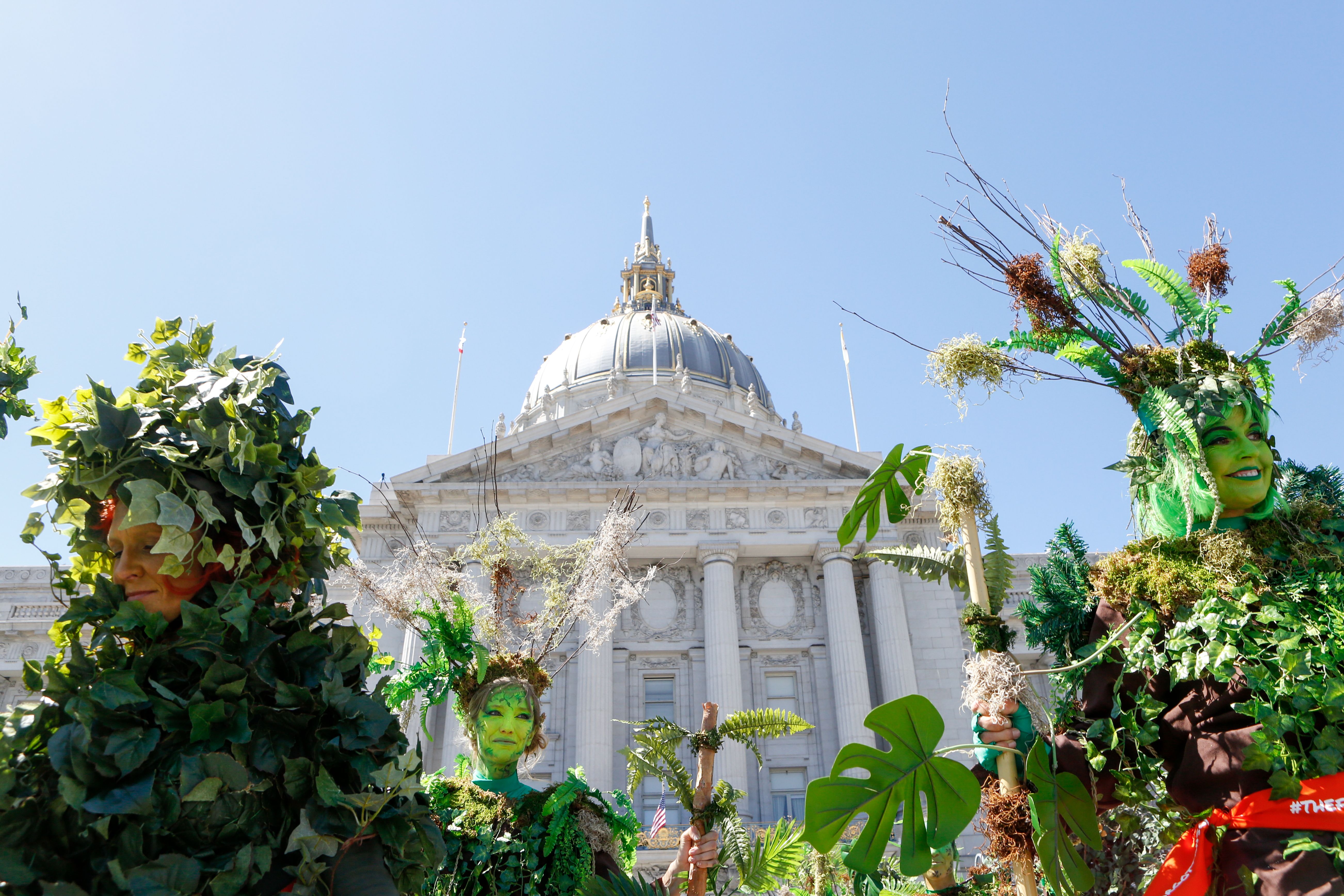 Women dressed as trees stand in front of San Francisco City Hall after marching in the Rise for Climate March on September 8th, 2018.