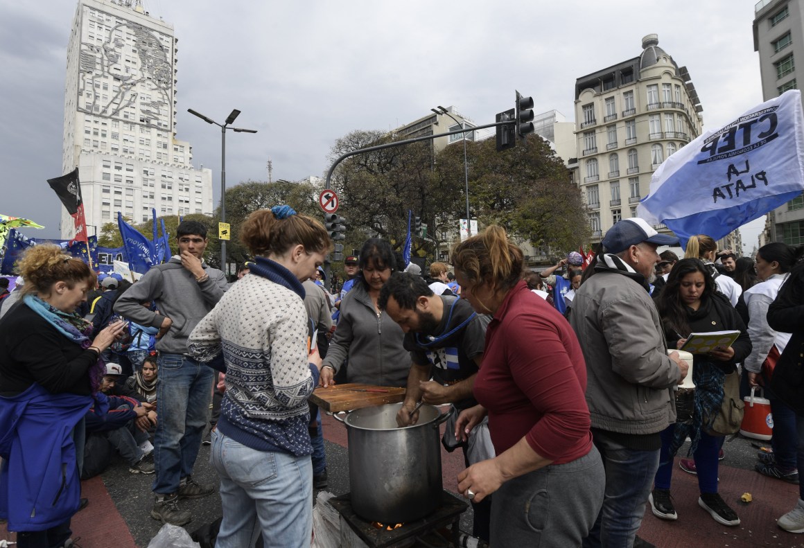 Volunteers prepare a free meal at a soup kitchen along 9 de Julio Avenue in Buenos Aires, backdropped by a portrait of Eva Peron on the wall of the Social Development and Health Ministry building, on September 12th, 2018, during a protest against the government of Argentine President Mauricio Macri. Argentinian social organizations are demanding the declaration of a food emergency amid a financial crisis that has increased in recent months. On Wednesday, demonstrators gave away food rations as a means of protesting the government.