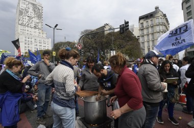 Volunteers prepare a free meal at a soup kitchen along 9 de Julio Avenue in Buenos Aires, backdropped by a portrait of Eva Peron on the wall of the Social Development and Health Ministry building, on September 12th, 2018, during a protest against the government of Argentine President Mauricio Macri. Argentinian social organizations are demanding the declaration of a food emergency amid a financial crisis that has increased in recent months. On Wednesday, demonstrators gave away food rations as a means of protesting the government.