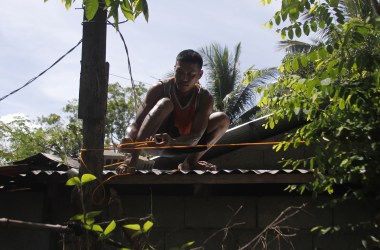 A resident secures the roof of his house to a tree in preparation for Super Typhoon Mangkhut in Candon City, Ilocos Sur province, north of Manila, on September 13th, 2018. The super typhoon, a Category 4 storm, roared toward the Philippines on September 13th, packing fierce winds and heavy rains that are expected to strike the disaster-prone nation during the weekend before moving on to China.