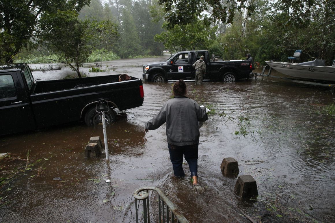 A resident walks from her flooded house toward the crew of the Cajun Navy in Lumberton, North Carolina, on September 15th, 2018, in the wake of Hurricane Florence.