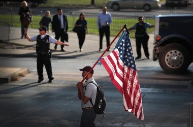 A demonstrator holds an American flag emblazoned with the names of victims who were fatally wounded by police officers during a protest outside the Leighton Criminal Courthouse Building on the first day of Chicago police officer Jason Van Dyke's murder trial on Monday, September 17th, 2018, in Chicago, Illinois. Van Dyke faces murder charges for shooting 17-year-old Laquan McDonald 16 times in an October of 2014 confrontation.