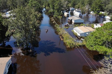 People walk through a flooded neighborhood after heavy rains brought on by Hurricane Florence on September 19th, 2018, in Lumberton, North Carolina.