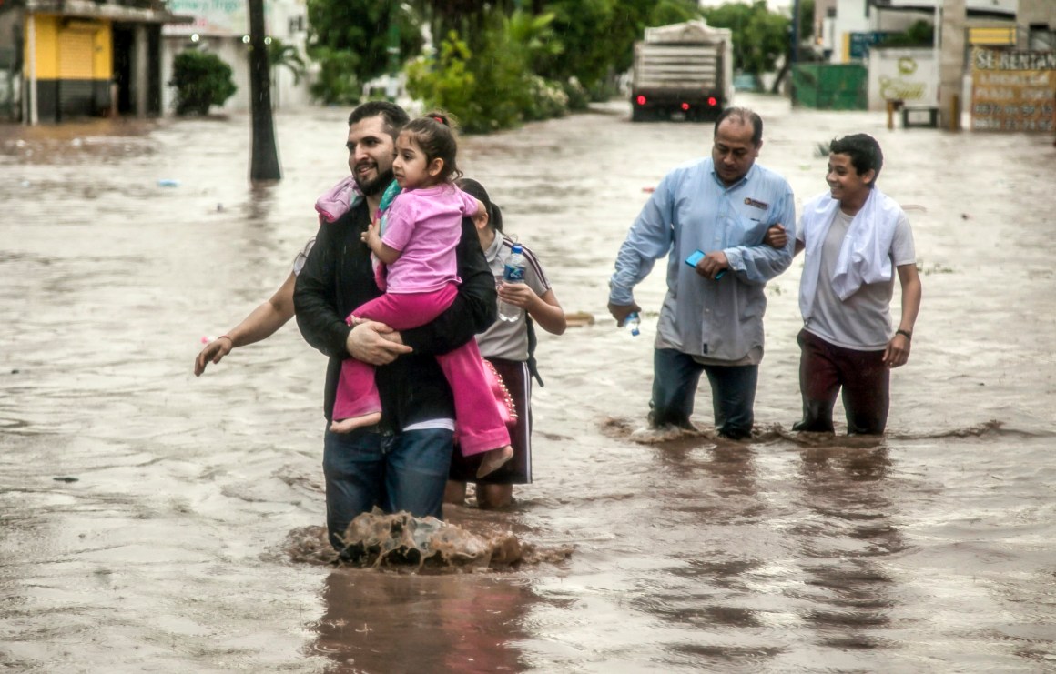 People wade through a flooded street in the city of Culiacán, in Sinaloa State, Mexico, on September 20th, 2018. Heavy rains flooded many of Culiacán's neighborhoods in just a few hours.