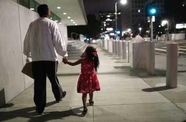 A Honduran man walks with his daughter near Metropolitan Detention Center on October 2nd, 2018, in Los Angeles, California.