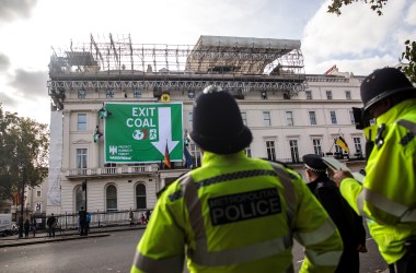 Police officers look on as Greenpeace activists hang from ropes after unfurling a banner outside the German embassy in a protest against coal on October 8th, 2018, in London, England. The stunt by the environmental campaign group came on the day that a report was released by the United Nations' top climate science panel calling for accelerated action to tackle climate change.